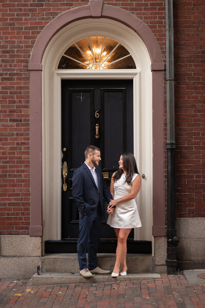 engagement photo of couple in Boston holding hands looking at each other