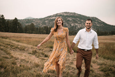 couple walks through field