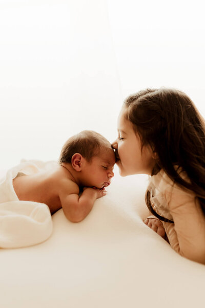 Baby girl being held by her mother wearing a cream knit romper in Oklahoma City.