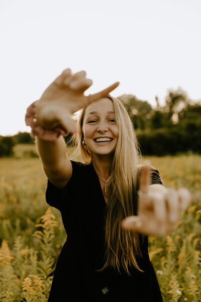 A girl laughing in a yellow field at sunset