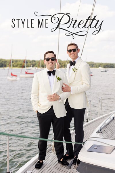 Grooms smiling during wedding portraits on sailboat at American Yacht Club in Rye, NY