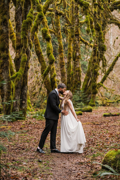 A couple stands in front of colorful buildings in leavenworth photographed by pnw adventure elopement photographer amy galbraith