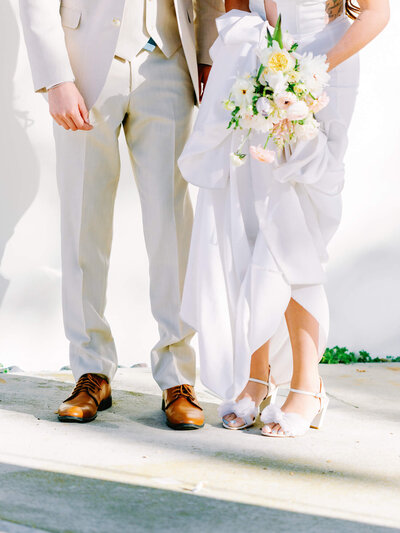 cropped photo of bride and groom holding bouquet standing next to each other