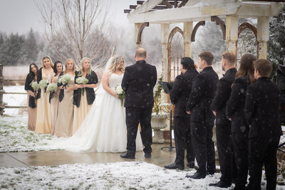 bride and groom holding hands while surrounded by bridal party