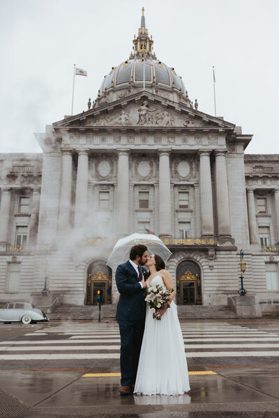 bride and groom crossing street in the rain