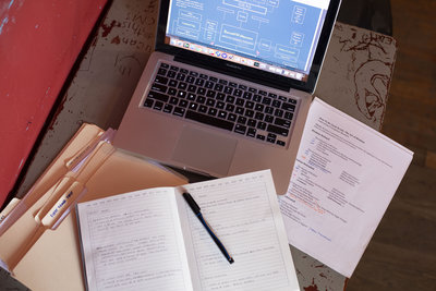 Flat lay of a laptop on a desk with handwritten notes and office supplies—professional branding photography for entrepreneurs and small business owners by Georgia photographer Christina Barnett.