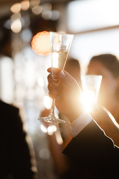 detail of champagne glasses being toasted