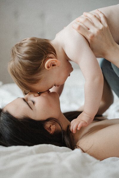 baby being kissed by mum