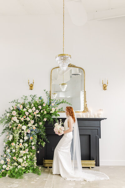 bride posing in front of a black fireplace