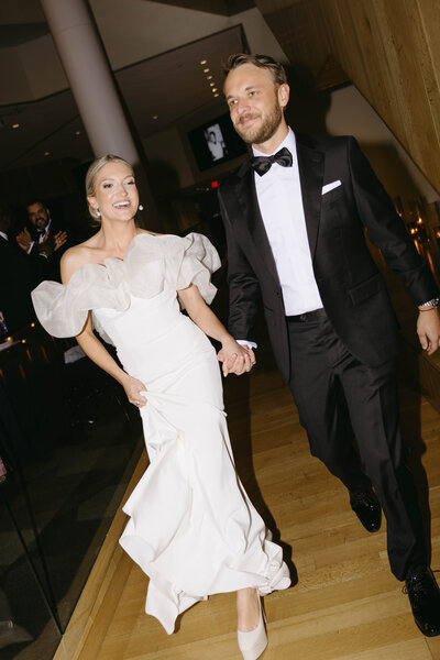 Bride and groom walking joyfully after wedding ceremony at reception hall