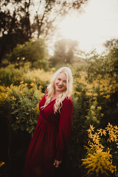 Photo of Erin Scott of One Shot Scott Photography. She is wearing. red dress and is looking at the camera and smiling
