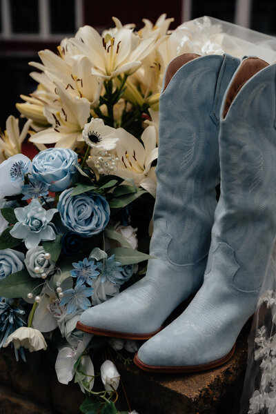 photo of blue cowgirl boots and blue flowers taken by montana wedding photographer