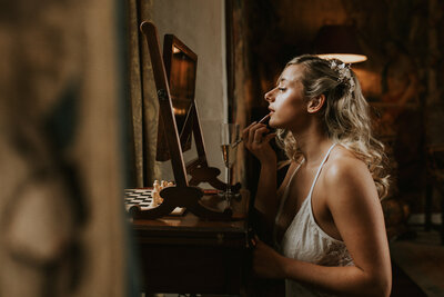 Woman putting on makeup before wedding