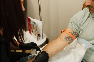 Close up of a nurse prepping to put an IV in a patient for his peptide therapy treatment.