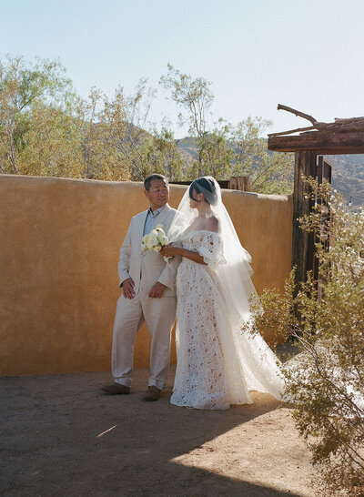 Father of the Bride and Bride walking together as he gives her away during Ceremony at luxury wedding.