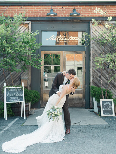 Couple kissing in front of venue taken by wedding photographer in frederick md, Nicole Simensky