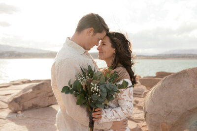 bride and groom embracing on beach