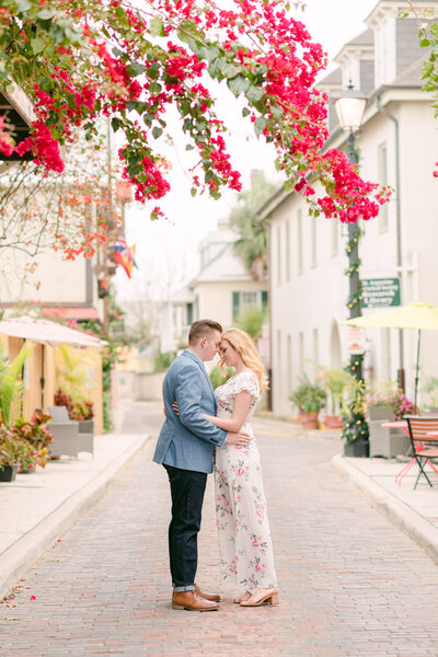 St. Augustine engagement with bride and groom standing under bougainvillea tree