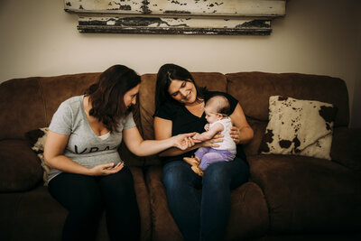 Midwife visiting mother and baby at home for postpartum support and newborn care