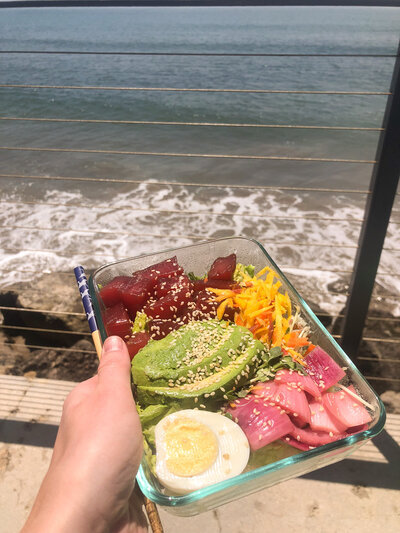 A homemade Poke bowl meal including raw tuna, avocado, egg and carrots.
