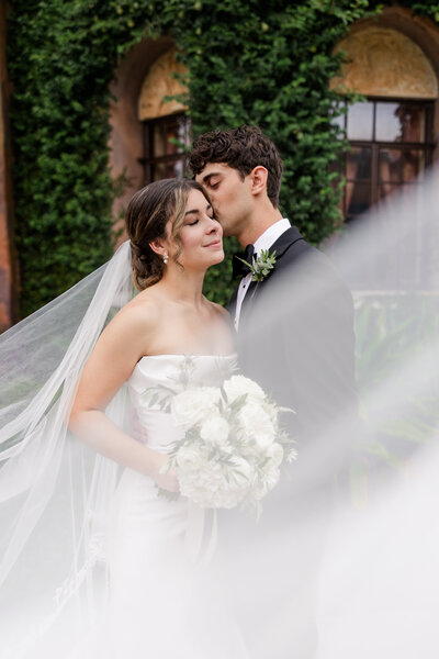 Groom kissing bride on forehead at Howey Mansion Wedding 