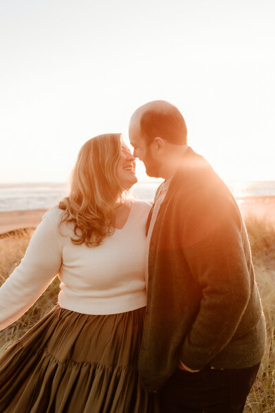 Hope and her husband about to kiss while the sun sets behind them.