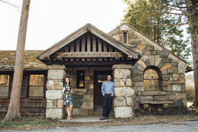 New Jersey Botanical Garden | Couple posing by historic house during spring engagement photo | Ringwood, New Jersey