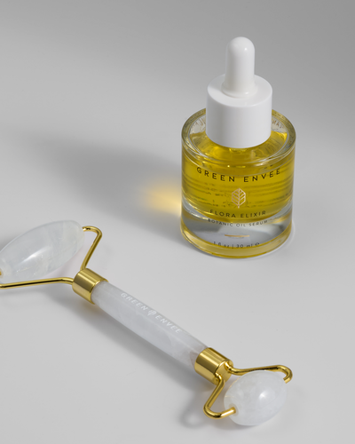 Close-up photo of Green Envee facial oil and jade stone roller. 