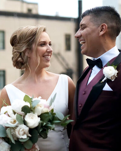 Bride and groom share a laugh during wedding portraits on Ambassador Hotel's rooftop in Chicago