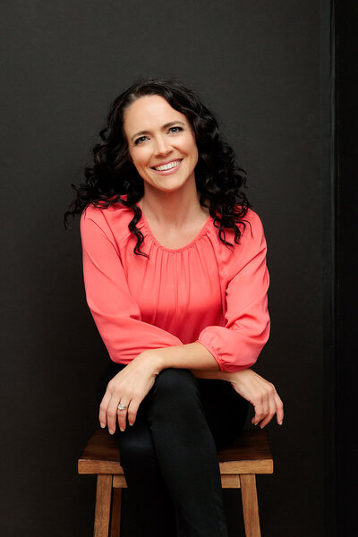 Los Angeles headshot photographer, Alyson Berg, smiles while holding her camera