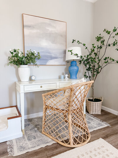 a white desk and wicker wood chair