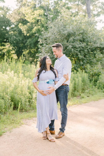 Father-to-be embraces his pregnant wife during maternity portraits