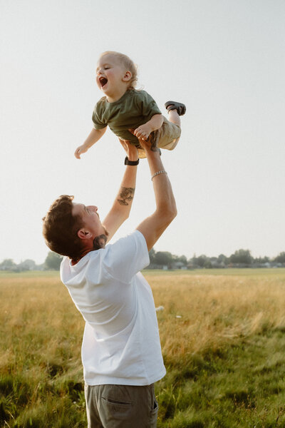 portrait of a father lifting his young son
