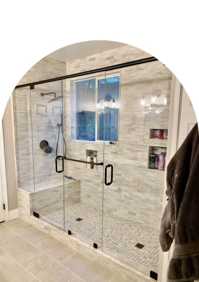 A Large Tan and grey shower tiled horizontally with black trim and two doors.
