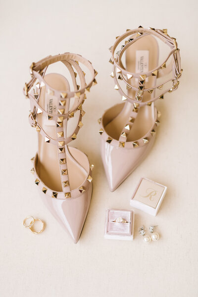Beautiful bridal details of Valentino shoes, wedding ring, and pearl earrings