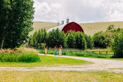 Guests walking toward red barn at Staubach Creek Ranch in Winston, MT