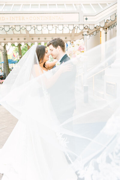 Couples kiss while brides veil flying in the air