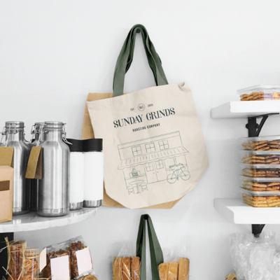 Sunday Grinds branding shown on a tote bag in the shop.