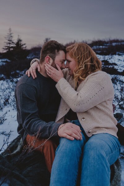 An engaged couple relaxes together during their engagement session at Glen Alps in Anchorage, Alaska