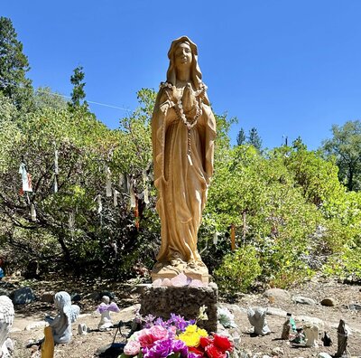 Mother Mary statue with brightly colored flowers sitting at the base