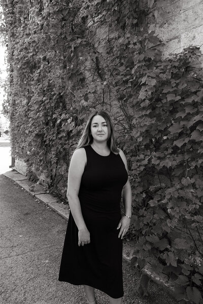 Danielle Aisling standing outside a historic stone building — cinematic, story-led wedding photographer based in Ottawa, Canada.