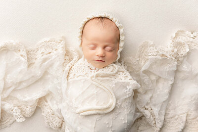 Newborn photography of baby in white lacy wrap in Portland Oregon Studio by Ann Marshall Photography