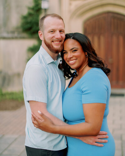 A couple with their arms around each other smiling 