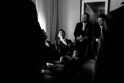 candid groom laughing with groomsmen before the wedding