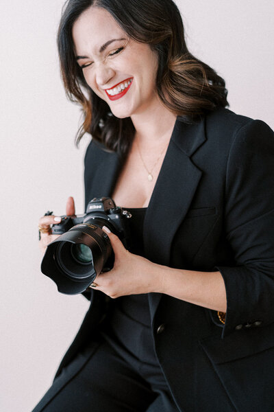 A portrait of Lindsey Ford holding her camera