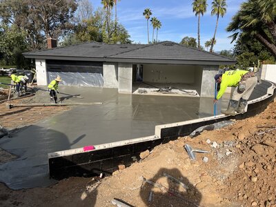 A front yard made mostly of gravel with a few water wise plants. There are large rocks creating a stream of small gravel running down the entire space. Landscaping Services done by Shamrock Solutions Construction based out of the Inland Empire California.