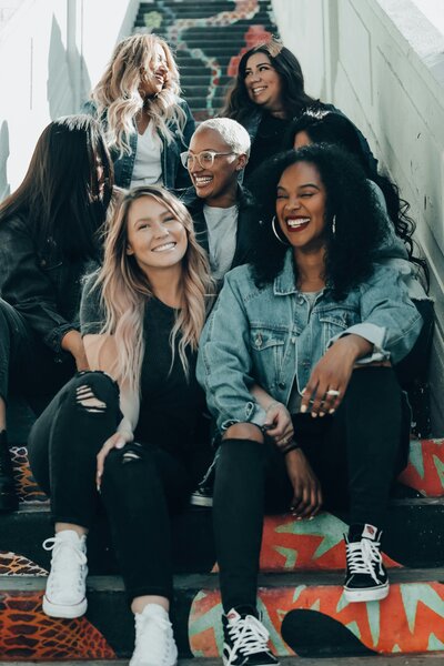 A diverse group of women standing together on the steps, symbolizing empowerment and teamwork. At Creative Dynamics, we value inclusivity and support women in achieving their professional goals. Photo courtesy of Joel Muniz on Unsplash.