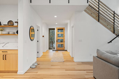 Entryway with a wooden door, staircase, and modern decor