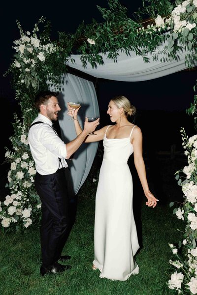 couple cheers espresso martini under chuppah at shelburne museum brick house wedding
