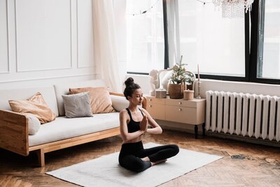 Woman in living room practicing yoga